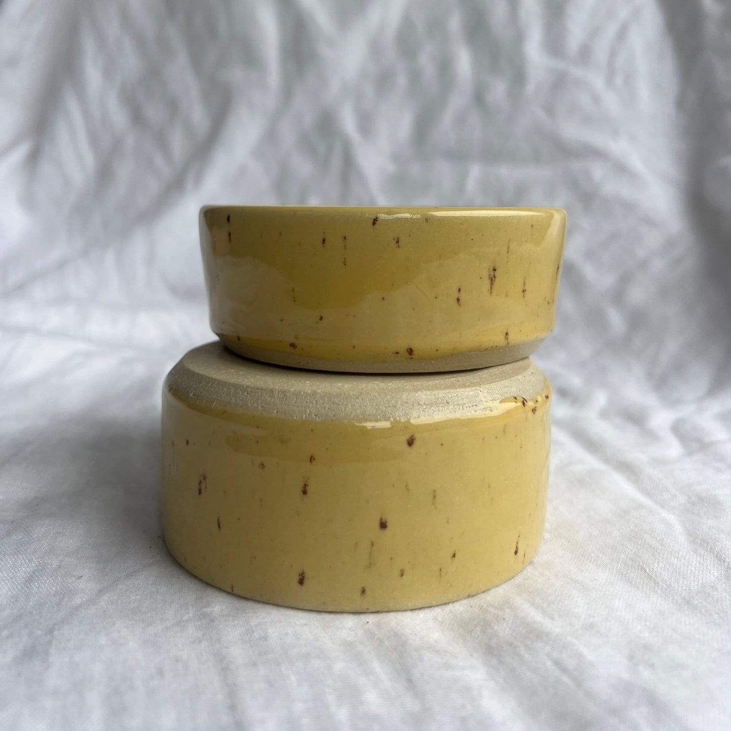 Yellow ceramic bowl on a white fabric background
